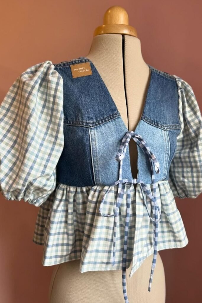 Upcycled top with a denim bodice, gingham puff sleeves and a ruffled hem on a dress form