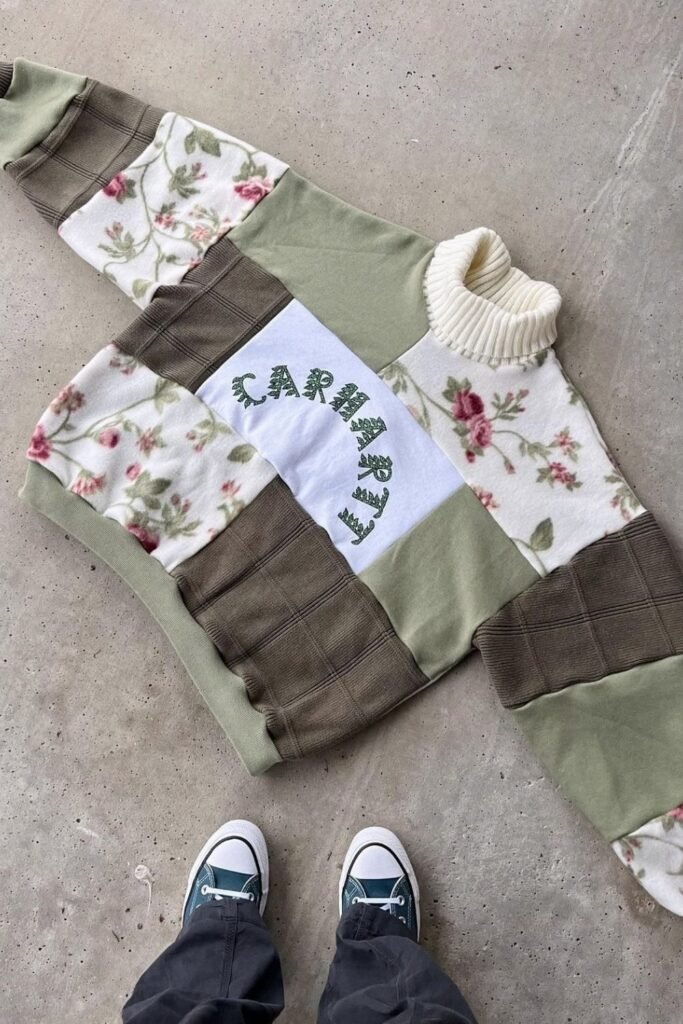 Patchwork sweatshirt with floral, green and brown fabric panels and a cream turtleneck