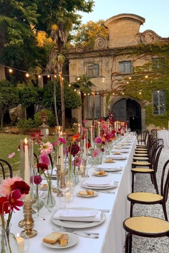 Long candlelit wedding table in a historic courtyard