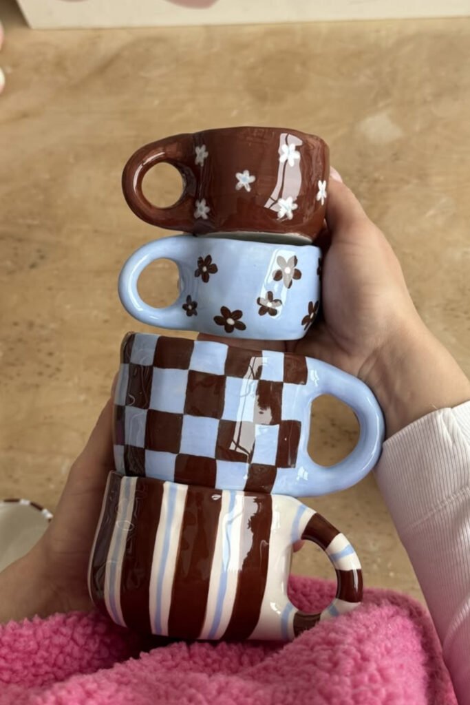 Stack of hand-painted mugs with checkerboard, stripes and polka dots