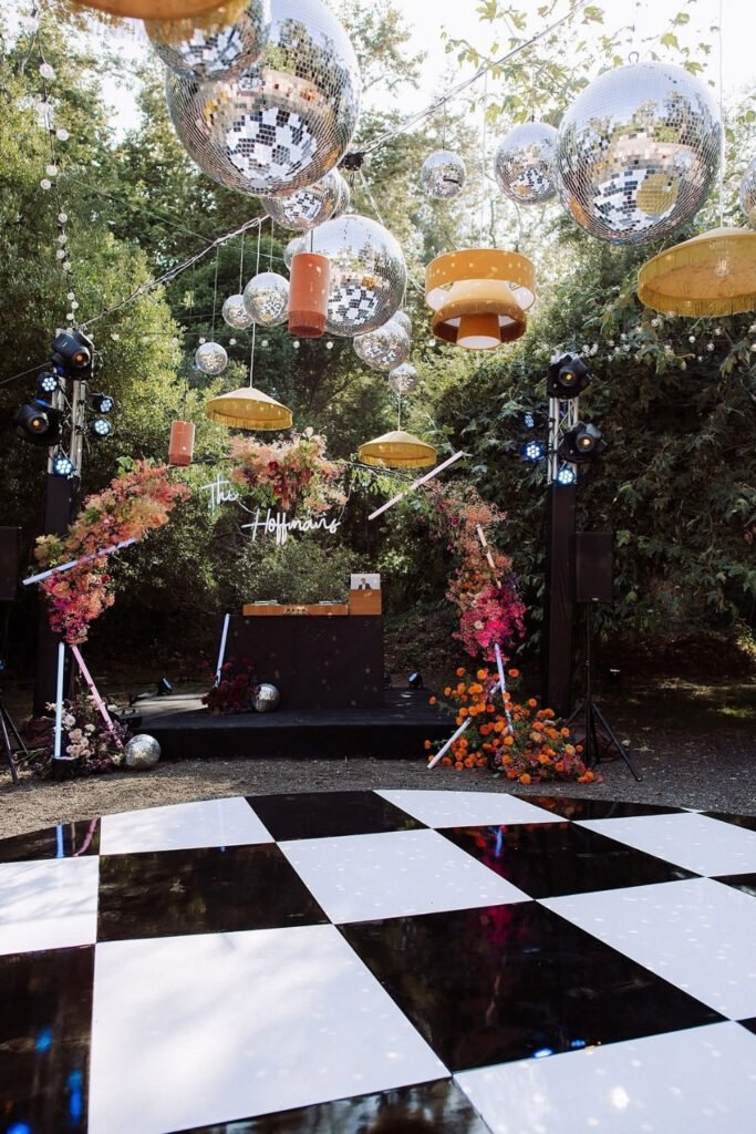 Disco balls hanging over a black and white checkered dance floor