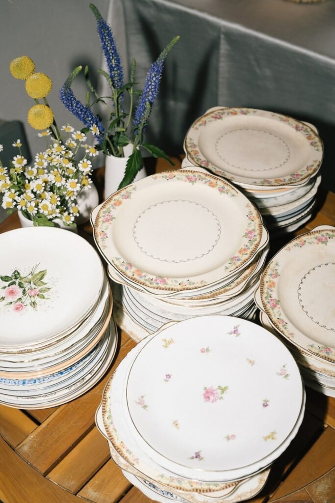 Stacks of mismatched vintage floral plates for a wedding table