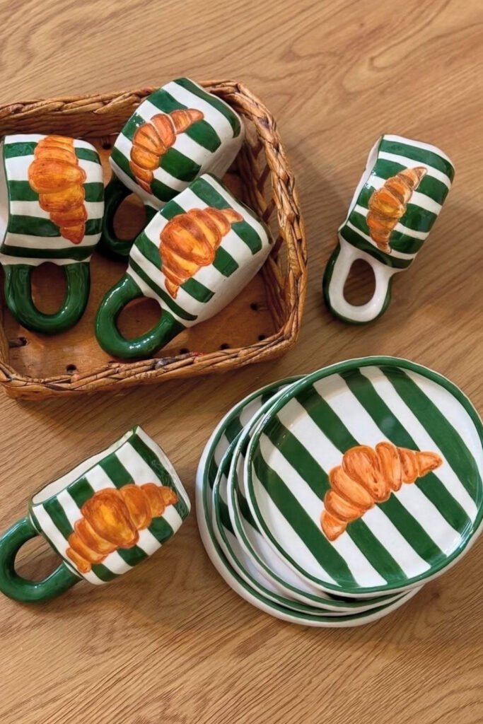 Matching set of striped mugs and plates painted with croissants