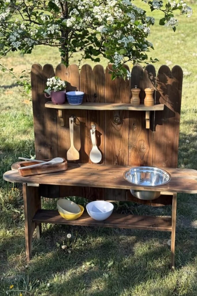Simple mud kitchen set up against a fence