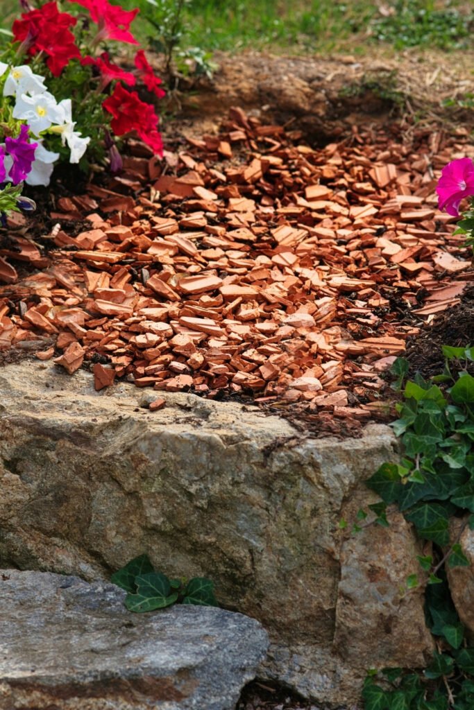 Garden bed with colorful petunias and dark mulch