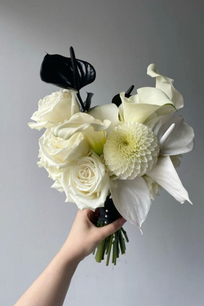 White roses and dahlias with black anthurium in a small bouquet
