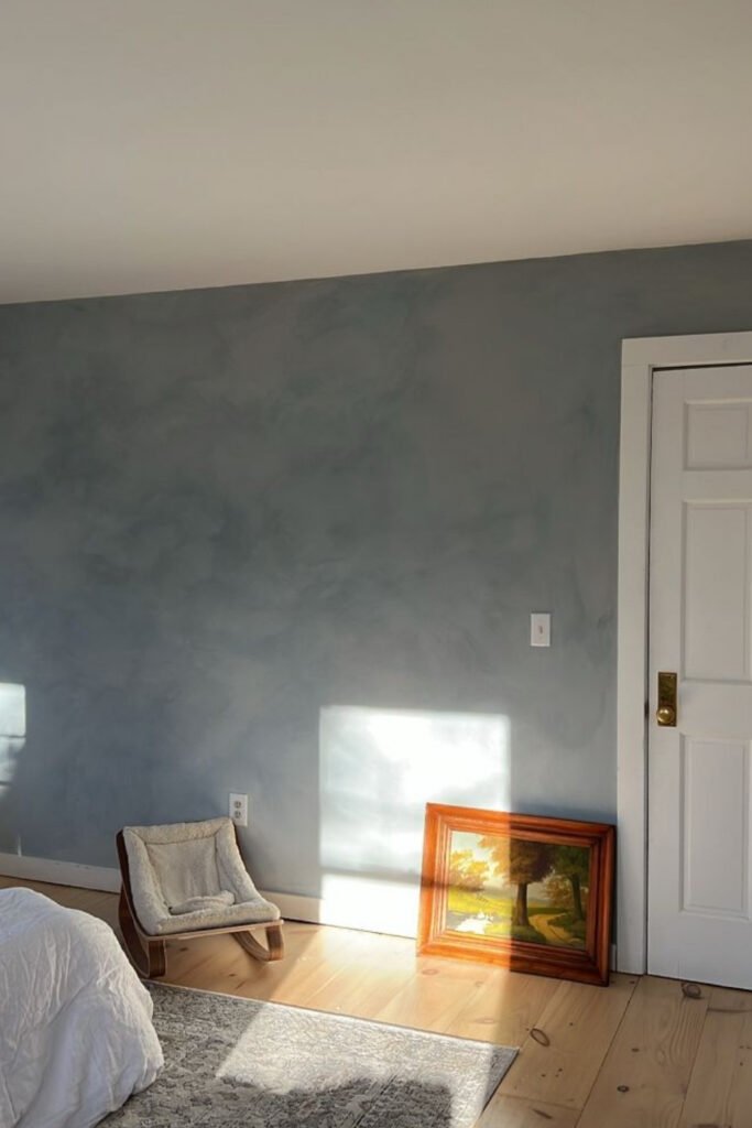 Bedroom with dusty blue-gray walls and natural light