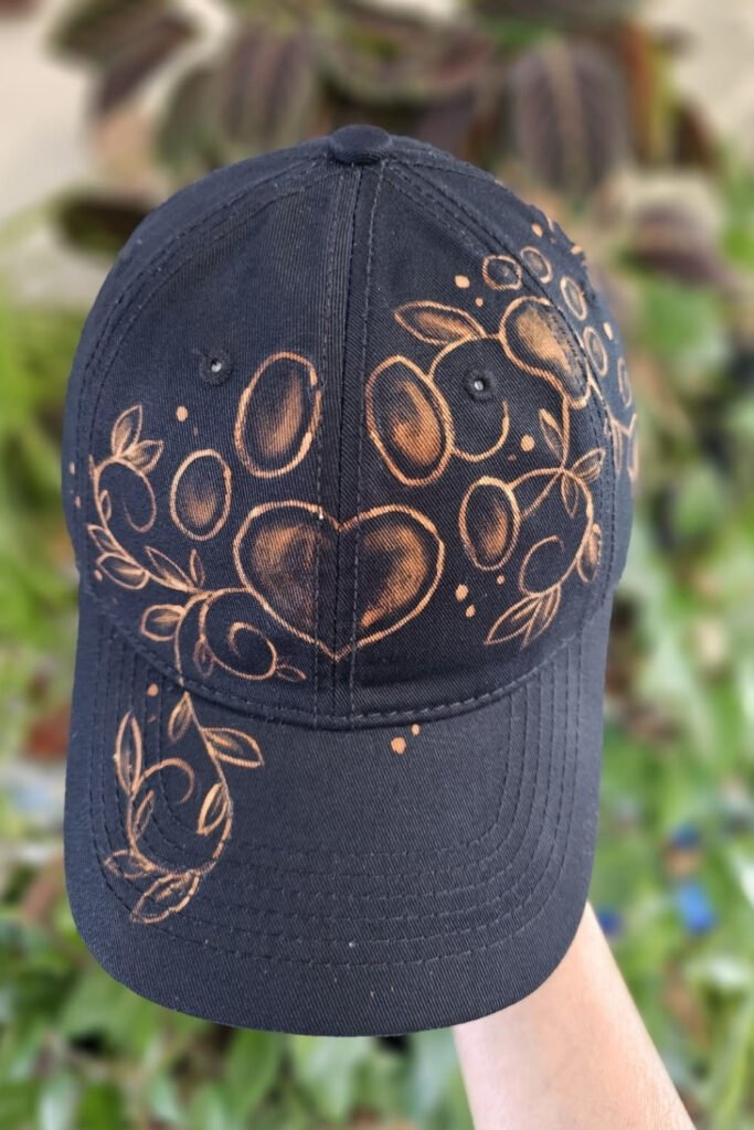Black baseball cap with a bleach-painted floral design