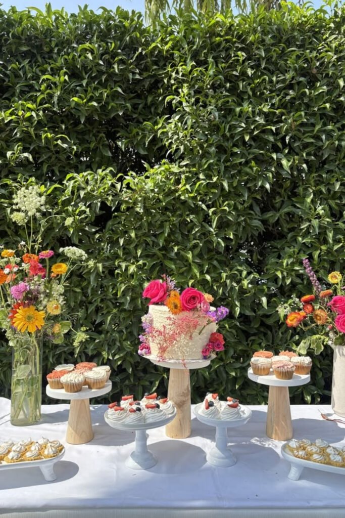Outdoor graduation dessert table with a white tablecloth