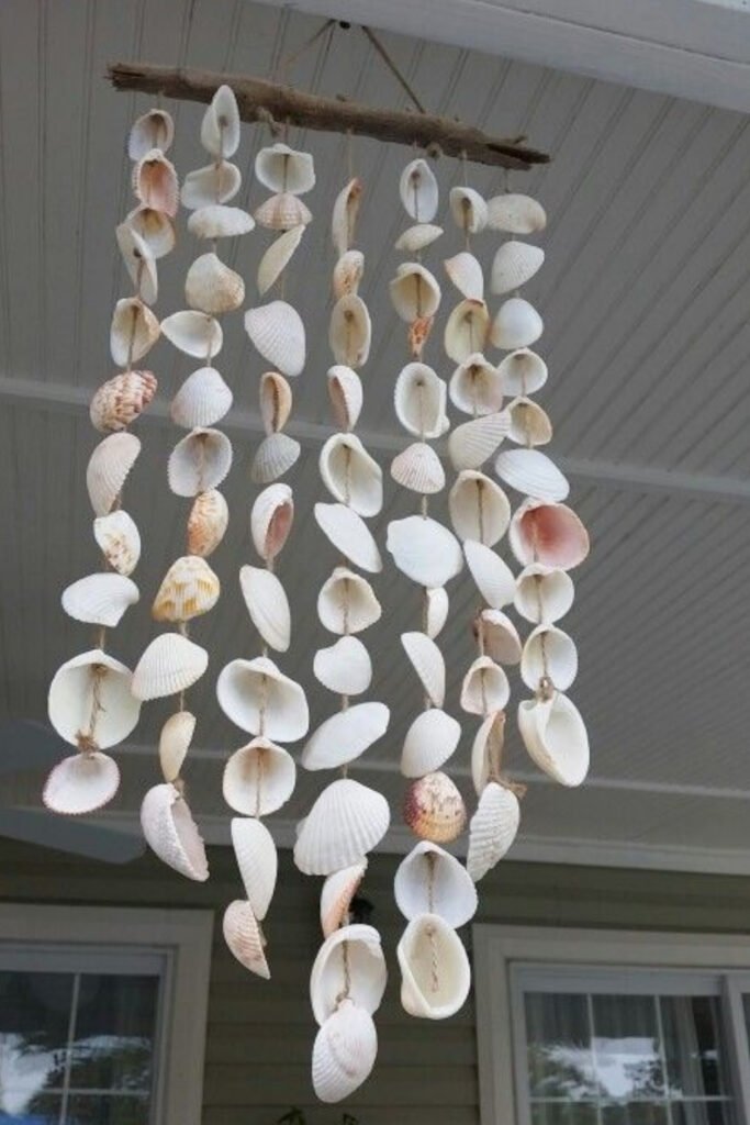 Long strands of white seashells hanging from a driftwood branch