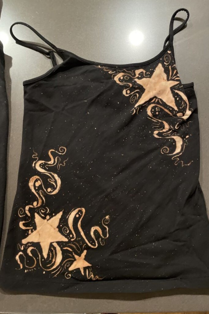 Black tank top with bleached stars and swirling lines