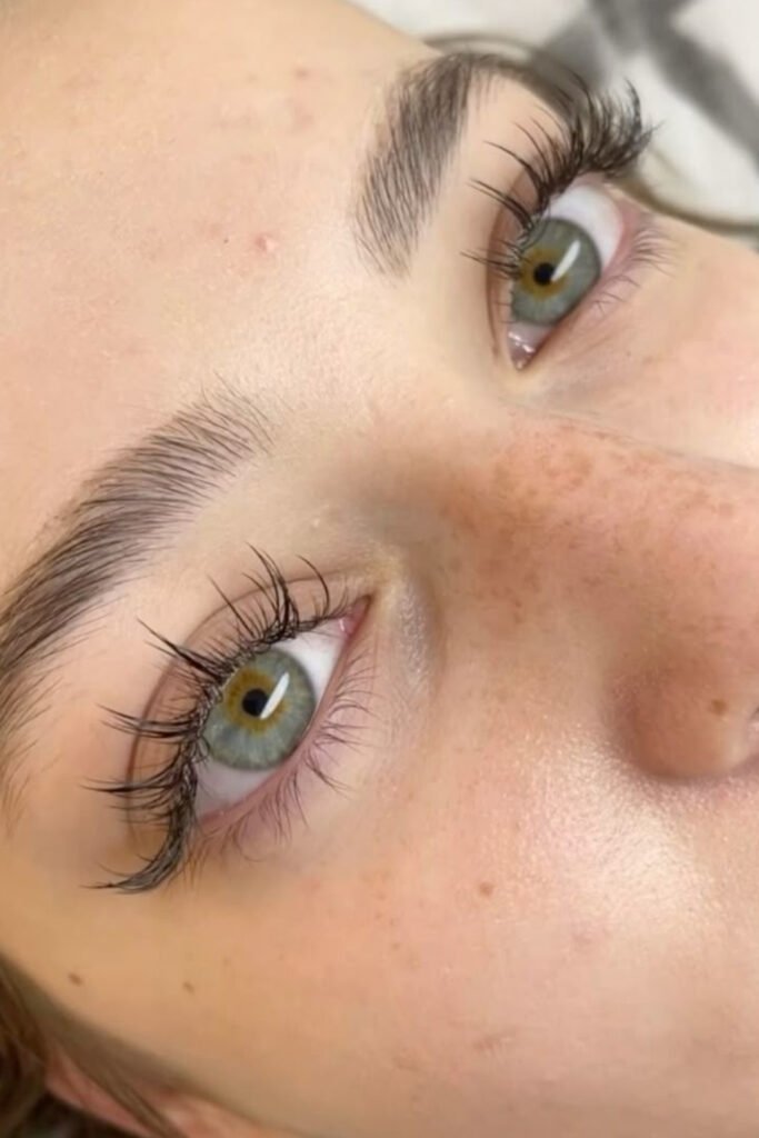 Close-up of natural-looking short eyelash extensions on green eyes