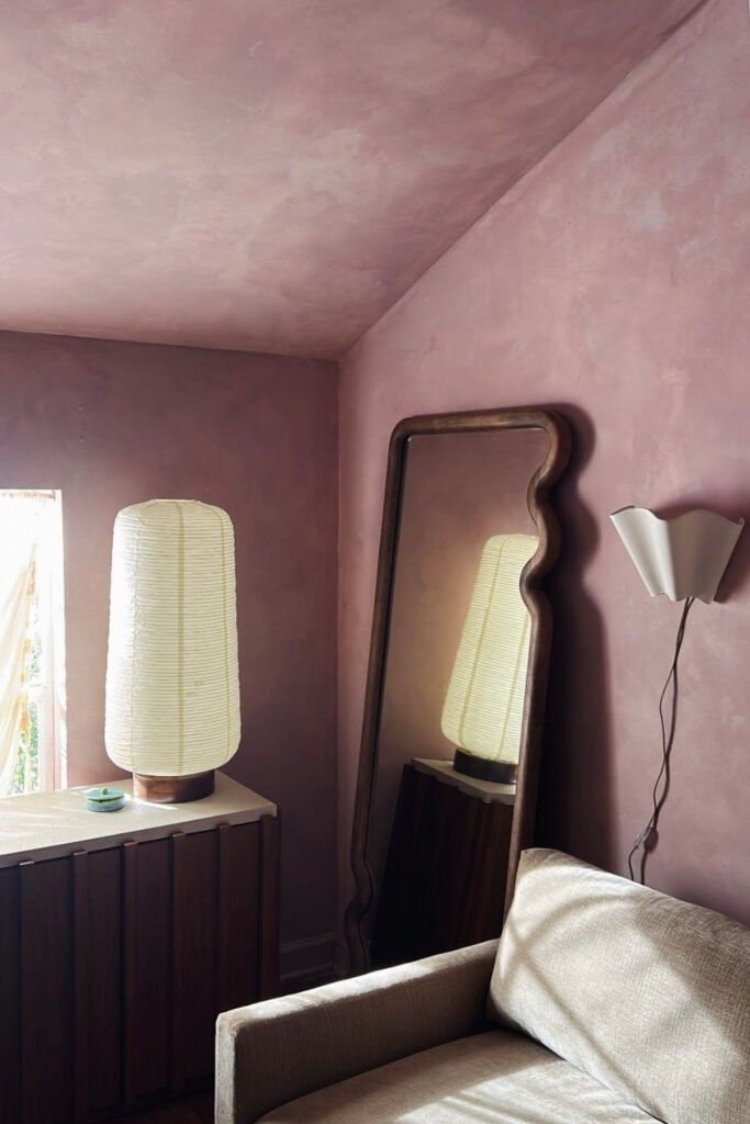 Bedroom with soft lavender walls, a white lamp and a tall mirror