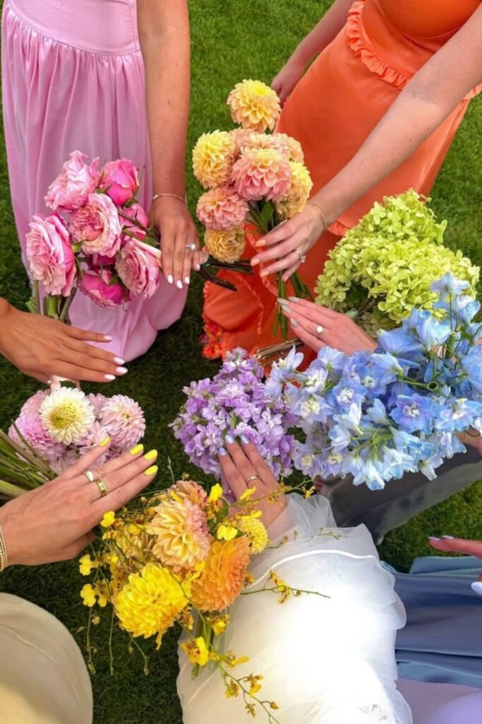 Bridesmaids holding bouquets in pink, orange, yellow and lavender