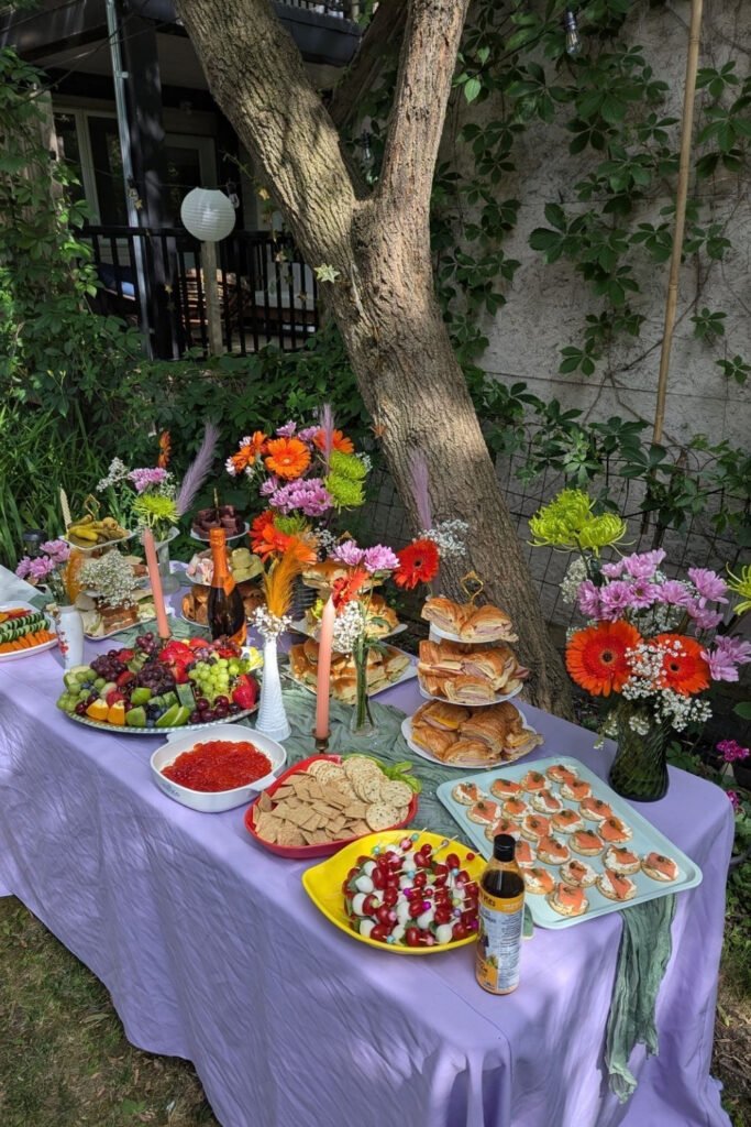Outdoor graduation party food table with a lavender tablecloth