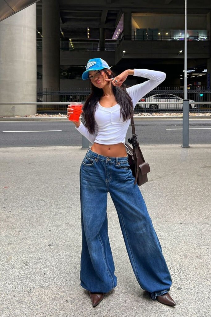 White fitted top, baggy jeans and pointed heels on a city street