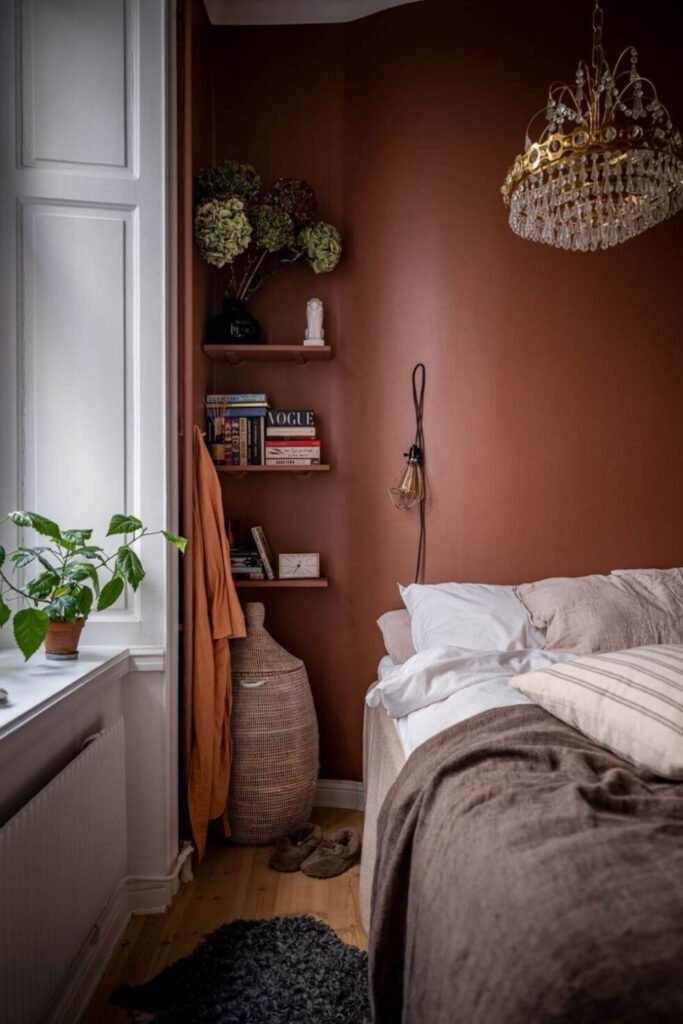 Bedroom with warm clay-colored walls, open shelving and soft bedding