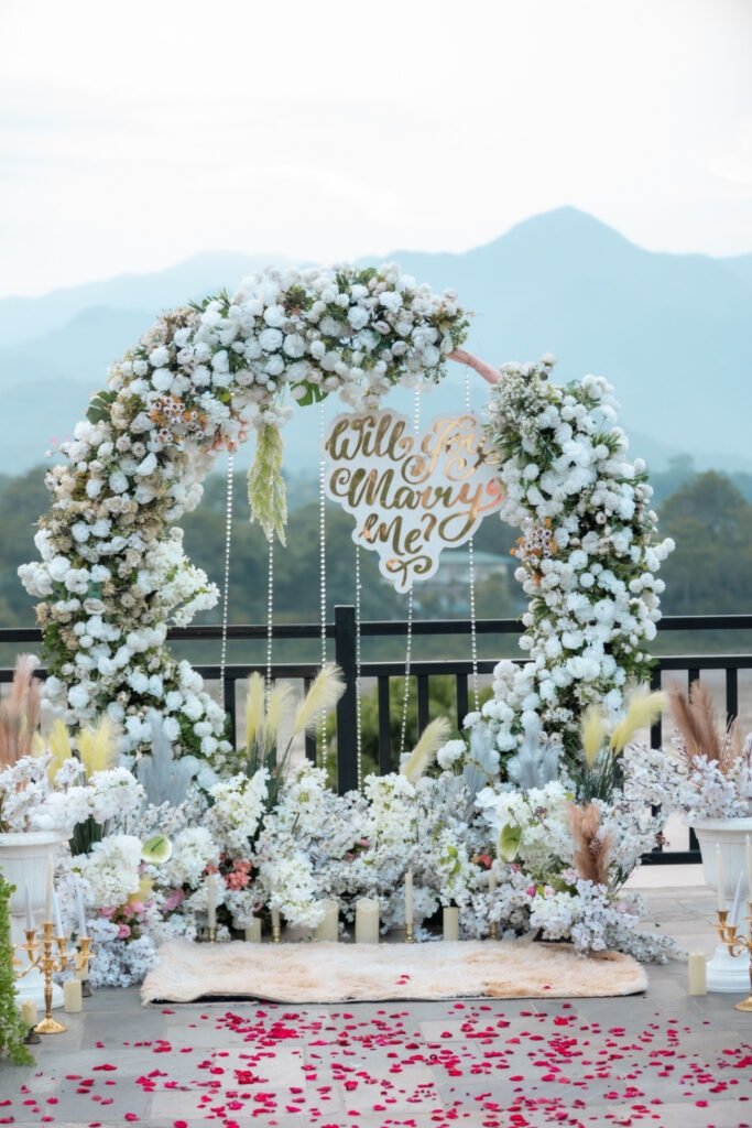 Round floral arch with white flowers and greenery overlooking mountains