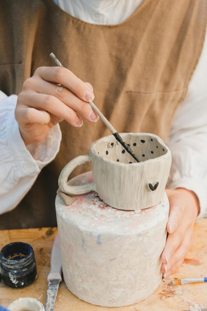 Painting a design onto an unglazed bisque cup