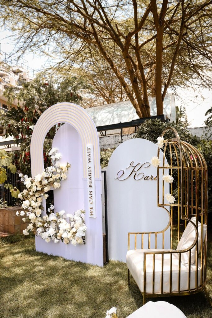 White arch panels with flower clusters placed at the corners in a garden