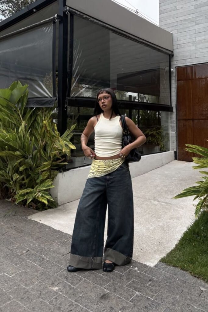 Fitted white top tucked into wide baggy jeans