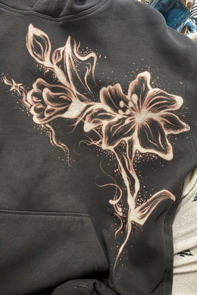 Black hoodie with a large bleach-painted flower design