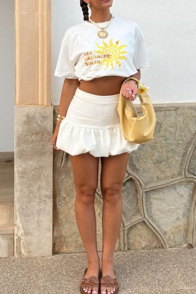 White tee tucked into a ruffled mini skirt