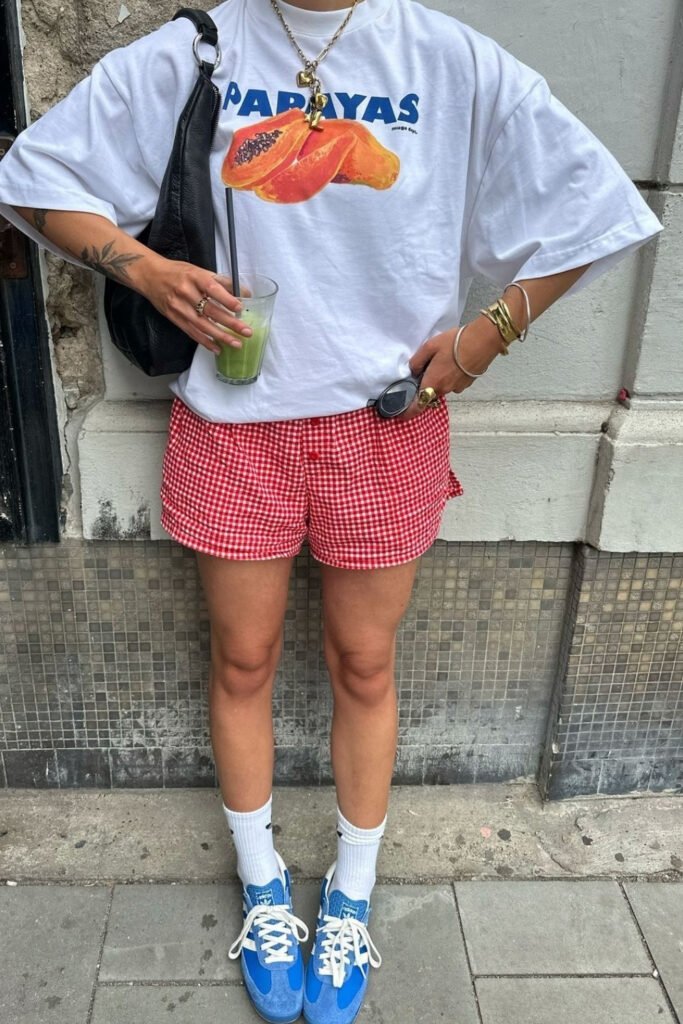 Graphic tee with red shorts and sneakers