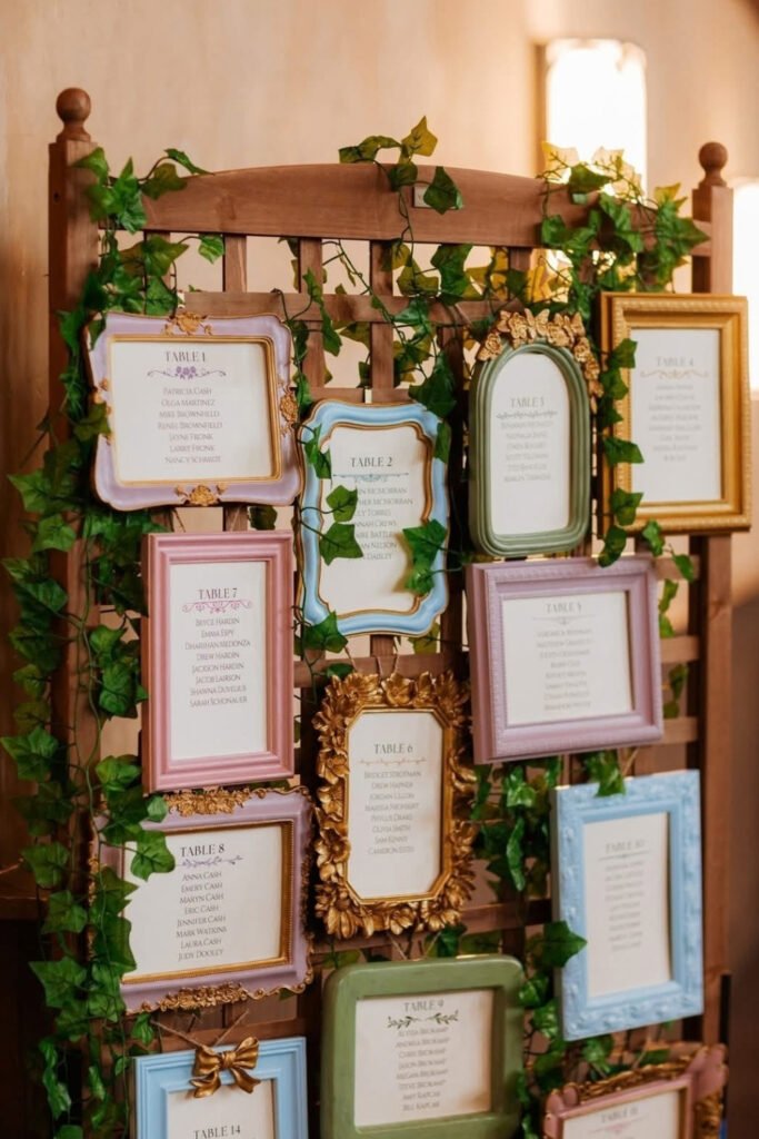 Vintage frames on an ivy-covered wall used as a wedding seating chart
