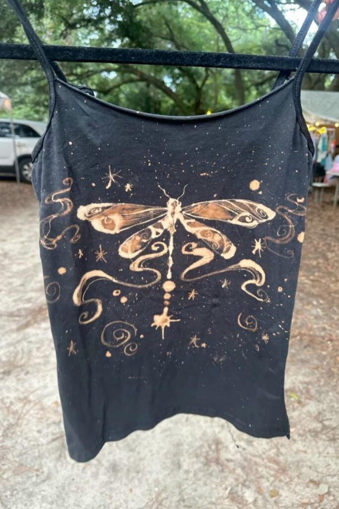 Black tank top with a bleach-painted dragonfly and decorative swirls