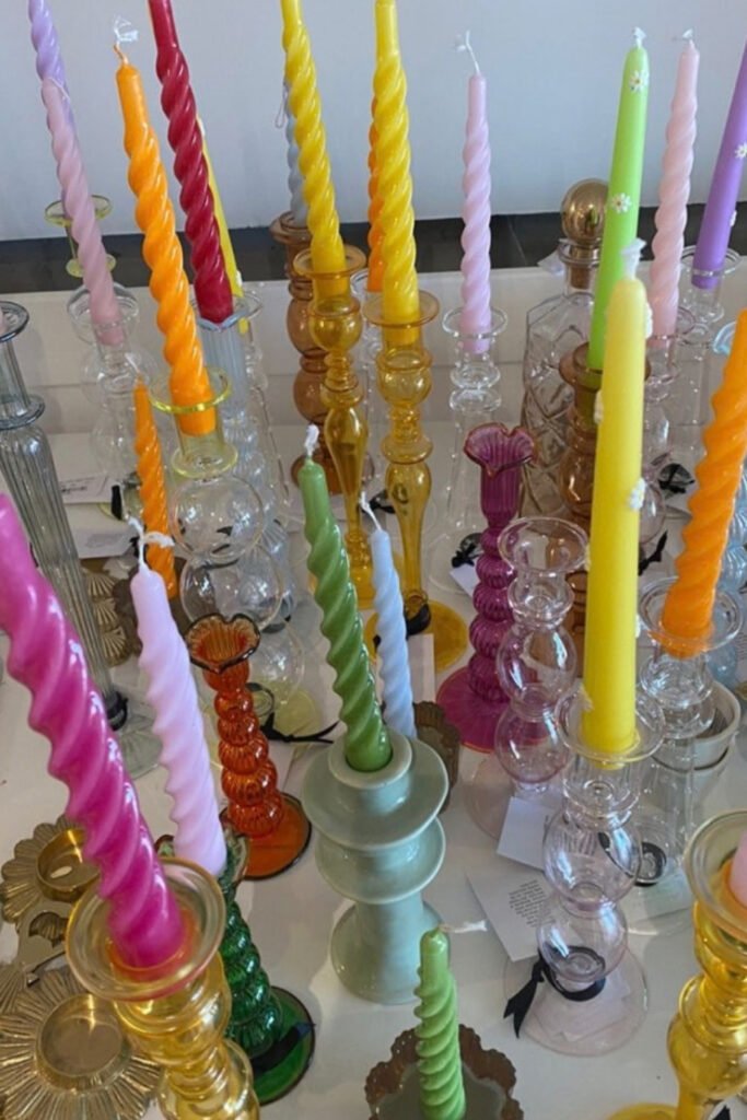 Colorful twisted taper candles in glass holders on a reception table