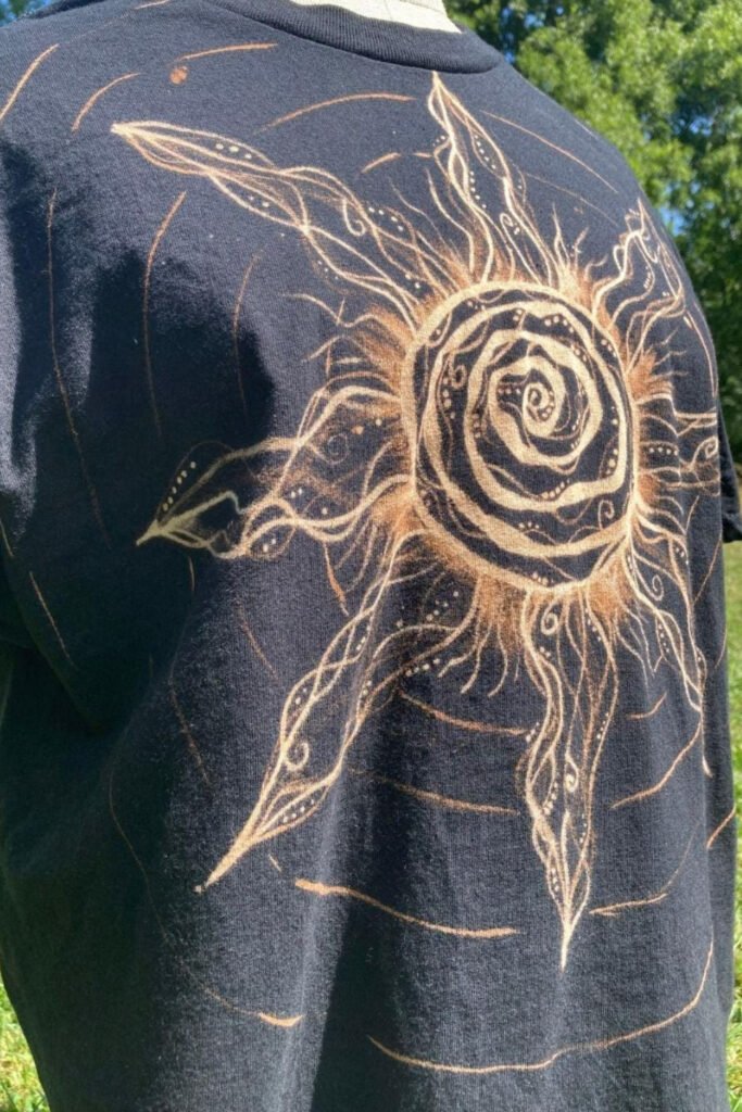 Black t-shirt with a bleached sun and rose design on the back