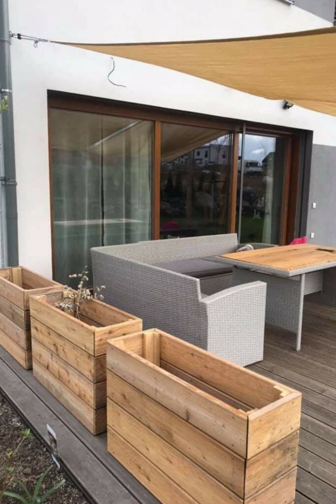 Wooden planter boxes around a patio seating area